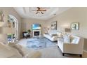 Bright living room with a fireplace, tray ceiling, neutral color palette, and tile flooring at 5106 Pine Shadow Ln, North Port, FL 34287