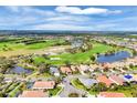 Expansive aerial view of a residential community nestled around a lush green golf course and serene lakes at 5109 Pine Shadow Ln, North Port, FL 34287