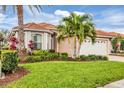 Beautiful home with well-manicured lawn, tropical landscaping, and distinctive terra cotta tile roof at 5109 Pine Shadow Ln, North Port, FL 34287