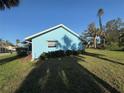 This view shows the side exterior of a cozy blue home with a green lawn, creating a cozy vibe at 519 Bellaire Dr, Venice, FL 34293