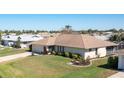 A single-story home situated on a well-maintained lawn with lovely landscaping and a screened lanai at 5875 Jackson, Venice, FL 34293