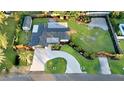 Aerial view of a home with a circular driveway, ample yard, and a shed in the back at 605 Cumberland Rd, Venice, FL 34293