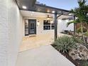 The entrance to a home with decorative landscaping and a tile walkway at 605 Cumberland Rd, Venice, FL 34293
