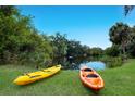 Waterfront view from the backyard with kayaks on the lawn at 651 Percheron Cir, Nokomis, FL 34275