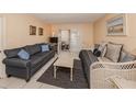 Living room with tile flooring, neutral paint, a sofa, a daybed, and sliding glass doors to a screened-in lanai at 708 Tamiami S Trl # 110, Venice, FL 34285