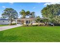 Well-maintained home with a green lawn, palm trees, and beautiful landscaping at 742 Golf Dr, Venice, FL 34285
