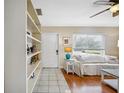 Cozy living room with wood-look flooring, white furniture, built-in shelving, and bright natural light at 742 Golf Dr, Venice, FL 34285