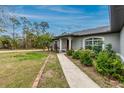 Charming single-story home featuring a sidewalk that leads to the front entrance surrounded by lush landscaping at 7809 Grafton Rd, North Port, FL 34291