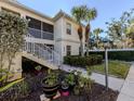 Lovely condo exterior with well-maintained landscaping, walkway, and stairs leading to the screened-in porch at 800 Gardens Edge Dr # 814, Venice, FL 34285