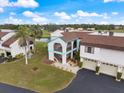 Two-story condo with exterior stairs and balcony overlooking pond and lush landscaping at 822 Capri Isles Blvd # 210, Venice, FL 34292