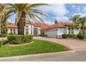 Attractive single-Gathering home with a lush green lawn, a beautiful red roof, and a brick driveway at 945 Chickadee Dr, Venice, FL 34285
