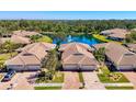 Aerial view showcases tiled-roof homes near serene lake with fountain at 1022 Yosemite Dr, Englewood, FL 34223