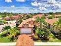 Inviting single-story home with a brick driveway, lush landscaping, and a two-car garage at 1088 Bluffwood Dr, Nokomis, FL 34275