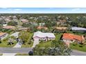 An aerial view shows this pink home situated in a lush green neighborhood under a sunny sky at 111 2Nd St, Nokomis, FL 34275
