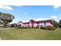 A delightful pink house featuring arched windows and a beautiful lawn on a sunny day at 111 2Nd St, Nokomis, FL 34275