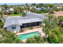 Aerial shot of back of the house featuring screened lanai, inground pool, landscaping, and partial roof at 1220 Lakeside Dr, Venice, FL 34293
