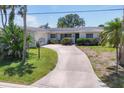 Charming single story home with a curved driveway and lush tropical landscaping in a beautiful setting at 1220 Lakeside Dr, Venice, FL 34293