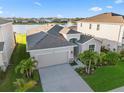 Aerial view of home overlooking a lake with a fountain and beautiful green landscaping at 12637 Promenade Estates Blvd, Sarasota, FL 34238