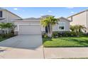 Exterior of home with a two-car garage, and lush green landscaping at 12637 Promenade Estates Blvd, Sarasota, FL 34238