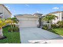 Exterior of home showcasing a two-car garage, manicured lawn, and fresh landscaping at 12637 Promenade Estates Blvd, Sarasota, FL 34238