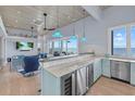 Stylish living room with a bar area, stainless steel refrigerator, and beautiful waterfront views at 14 Grouper Hole Dr, Boca Grande, FL 33921