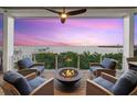 Cozy outdoor patio with a fire pit and seating area overlooking the water at 14 Grouper Hole Dr, Boca Grande, FL 33921