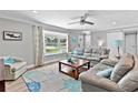 Cozy living room with a bay window, comfortable seating, a ceiling fan, and stylish decor at 150 Fiesole St, Venice, FL 34285