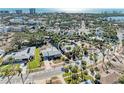 An aerial view showcases a single-story home with mature palm trees and proximity to shops and the beach at 153 N Adams Dr, Sarasota, FL 34236