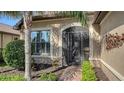 Close-up of the front entrance with a decorative security door, beautiful plants and meticulous landscaping at 19651 Quisto St, Venice, FL 34293