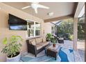 Inviting covered patio with comfortable seating, tropical plants, and a view of the lush backyard at 2042 Mesic Hammock Way, Venice, FL 34292