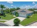 Charming single-story home featuring a well-manicured lawn, lush landscaping, and a two-car garage at 213 Bayside Ct, Nokomis, FL 34275