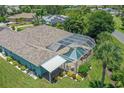 Aerial view of a home with a screened-in pool area, patio, lush landscaping, and well-maintained lawn at 213 Bayside Ct, Nokomis, FL 34275