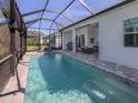Relaxing screened-in pool with lounge chairs and an outdoor living area at 29176 Coral Harbour Dr, Englewood, FL 34223