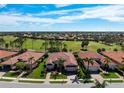 Expansive aerial view of a neighborhood showcasing well-maintained homes, lush landscaping, and a scenic golf course at 297 Martellago Dr, North Venice, FL 34275