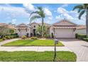 Beautiful single-story home with a lush front lawn, a palm tree, a tile roof, and a two-car garage at 297 Martellago Dr, North Venice, FL 34275