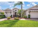 Charming home with a manicured front yard, tile roofing, and a private entrance with mature landscaping at 297 Martellago Dr, North Venice, FL 34275