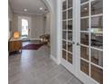 Inviting entryway features gray tile floors, neutral walls, an arched doorway and an adjacent study with French doors at 500 Padova Way, North Venice, FL 34275