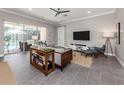 Spacious living room featuring tile floors, neutral walls, ceiling fan and sliders leading to outdoor pool area at 500 Padova Way, North Venice, FL 34275
