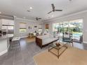 Open-concept living area with tile floors, connecting the living room, kitchen and dining space with sliders to pool at 500 Padova Way, North Venice, FL 34275