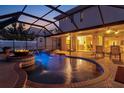 Gorgeous screened-in pool with water features, fire pit, and covered patio at 632 Valencia Rd, Venice, FL 34285