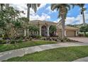 Stunning exterior view of a home with manicured landscaping, mature trees, and a welcoming entrance at 7120 Grassland Ct, Sarasota, FL 34241