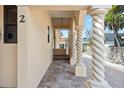 Exterior showing a charming covered entryway with decorative columns and a brick-paved path leading to the front door at 718 Golden Beach Blvd # 2, Venice, FL 34285