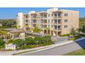 Attractive multi-story condo building with balconies, a pool, a cabana, and well-maintained landscaping at 830 The Esplanade N # 201, Venice, FL 34285