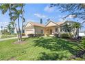 Single Gathering home featuring mature palms, a well maintained lawn, and cream-colored stucco at 8603 46Th Avenue W Cir, Bradenton, FL 34210