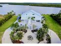 Elegant waterfront home featuring mature landscaping, circular drive, and covered parking at 9061 Kellogg Ln, Venice, FL 34293