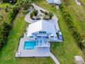 Beautiful waterfront home with outdoor patio, pool, and well manicured lawn at 9061 Kellogg Ln, Venice, FL 34293