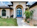 Charming front entry with blue double doors, manicured landscaping, and stone walkway at 9407 Prospect Ave, Englewood, FL 34224