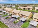 Aerial view of a well-maintained two-story condo community with carports, ponds, and mature landscaping at 410 Mission E Trl # H, Venice, FL 34285