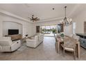 Open concept living room and dining area with a view of the screened-in pool and lake beyond at 129 Cipriani Way, North Venice, FL 34275