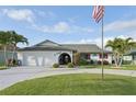 Inviting single-story home boasting a lush green lawn, palm trees, and classic architecture at 1300 Lucaya Ave, Venice, FL 34285